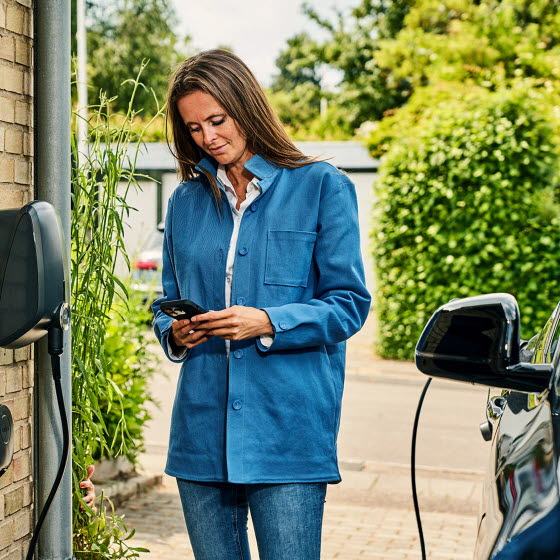 Kvinde ved OK-ladeboks med OK-appen