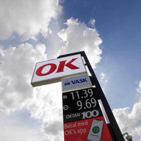 Prisskilt med OK-logo, bilvaskikon og brændstofpriser