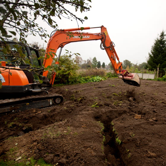 Gravemaskine i færd med at grave rende til jordvarmeanlæg