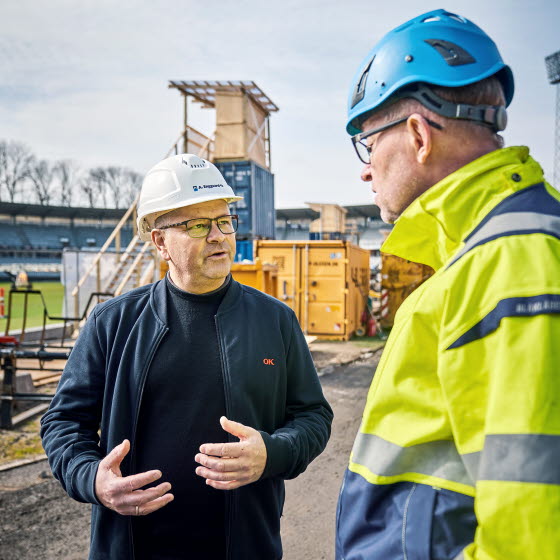 To mænd taler sammen på en byggeplads