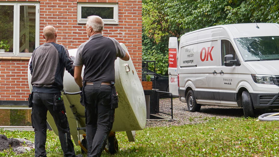 To mænd i færd med at fjerne en olietank